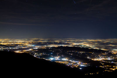 Aerial view of illuminated cityscape against sky at night