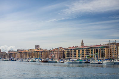 Buildings by river against sky