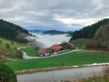 Scenic view of field by buildings against sky