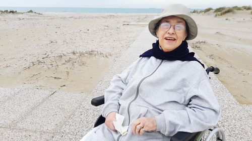 Happy sitting on wheelchair at beach