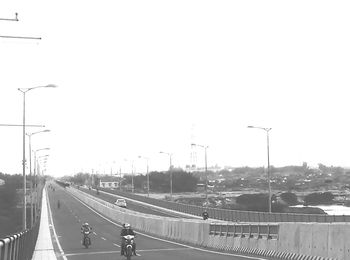 Traffic on highway in city against clear sky