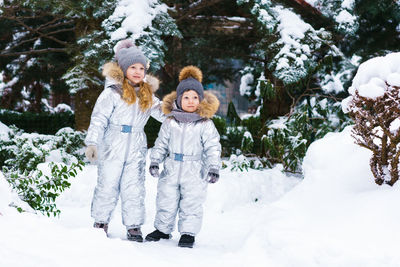 Two little cheerful children on snowy frosty day. brother and sister play