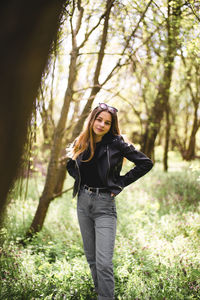 Portrait of young woman standing in forest