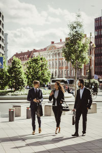 Female entrepreneur discussing strategy with male colleagues while walking outdoors