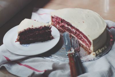 Red velvet cake with cake server and fork served on table