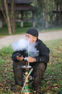Rear view of man welding in forest