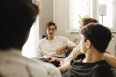 Young multi-ethnic male friends spending leisure time at home