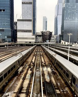 Railroad tracks amidst buildings in city against sky