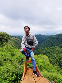 Portrait of man standing on mountain against sky