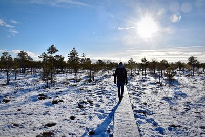 Rear view of woman on snow covered land against sky