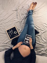 Low section of woman lying on bed