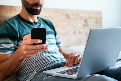 Midsection of man using mobile phone