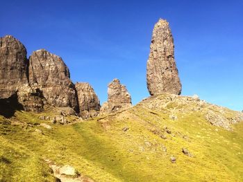 Low angle view of rock formations against blue sky