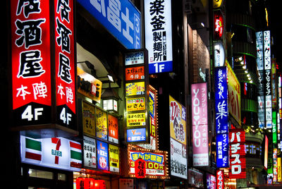 Illuminated information signs on buildings in city at night