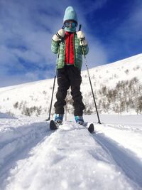Boy skiing against sky