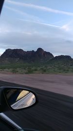 Car on road by mountains against sky