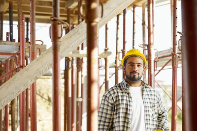 Portrait of young man standing at construction site