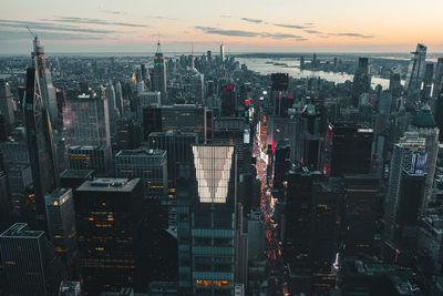 Modern buildings in city against sky during sunset