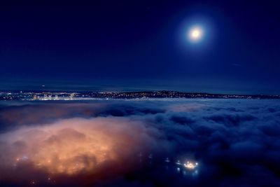 Aerial view of illuminated sea against sky at night