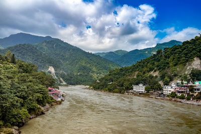 Scenic view of river amidst trees against sky