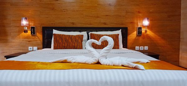 View of illuminated electric lamp on bed at home