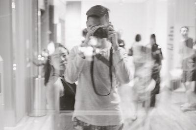 Reflection of woman photographing on glass