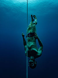 Shirtless man swimming in sea