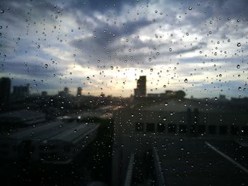 City seen through wet glass window during rainy season