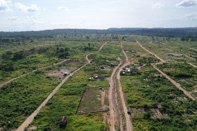 High angle view of road amidst field against sky