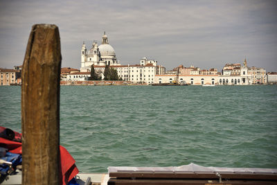 View of buildings by sea against sky