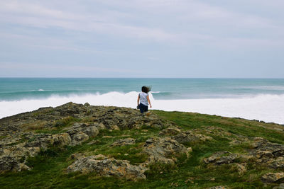 Rear view of woman looking at sea against sky