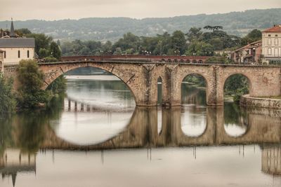 Arch bridge over river against sky