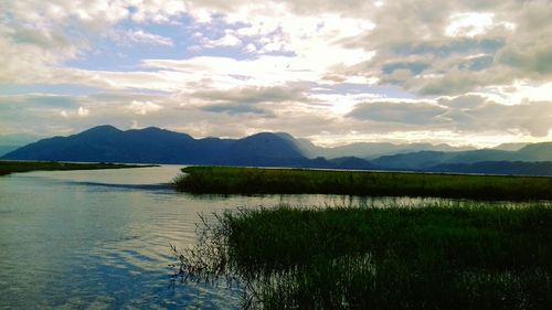 Scenic view of lake and mountains against sky