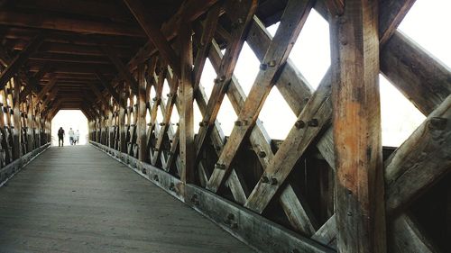 Rear view of man walking on bridge