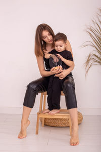 Portrait of young woman sitting on floor at home