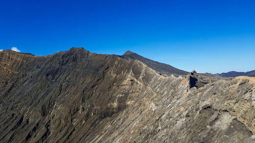 Scenic view of mountains against clear blue sky