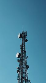 Low angle view of windmill against clear blue sky