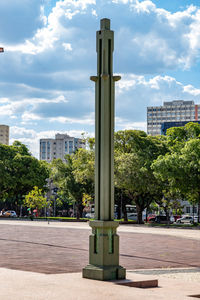 Street by trees and buildings against sky