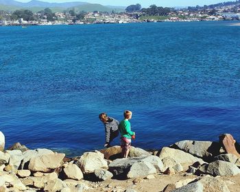 Friends standing at rocky sea shore