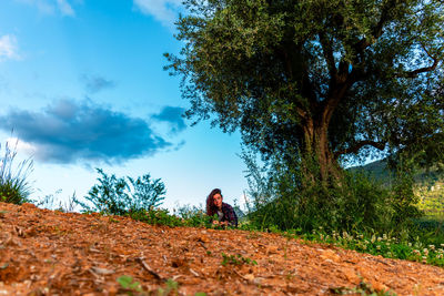 Rear view of man standing on field against sky