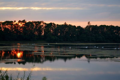 Scenic view of lake against sky at sunset