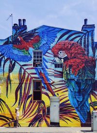 Low angle view of birds on building against sky