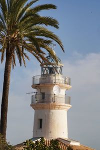 Lighthouse by sea against sky