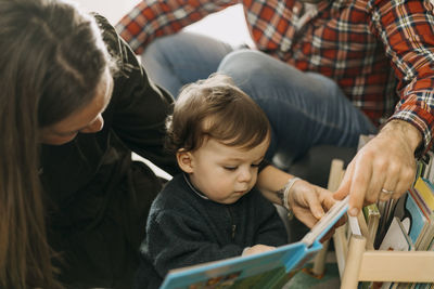 Parents reading a book to son at home