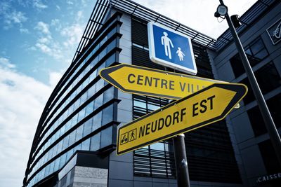 Low angle view of information sign against sky