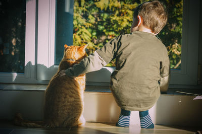 Rear view of man and cat at home