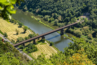 The steel truss structure of the railway bridge seen from above, in the background there are hills.