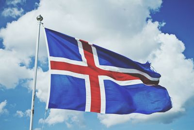 Low angle view of flag against blue sky