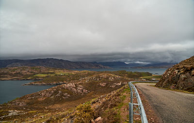 Road leading towards mountains against sky
