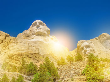 Low angle view of statue against clear blue sky